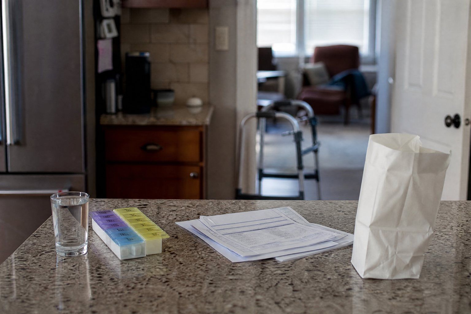 Discharge papers and a weekly pill organizer on a kitchen counter